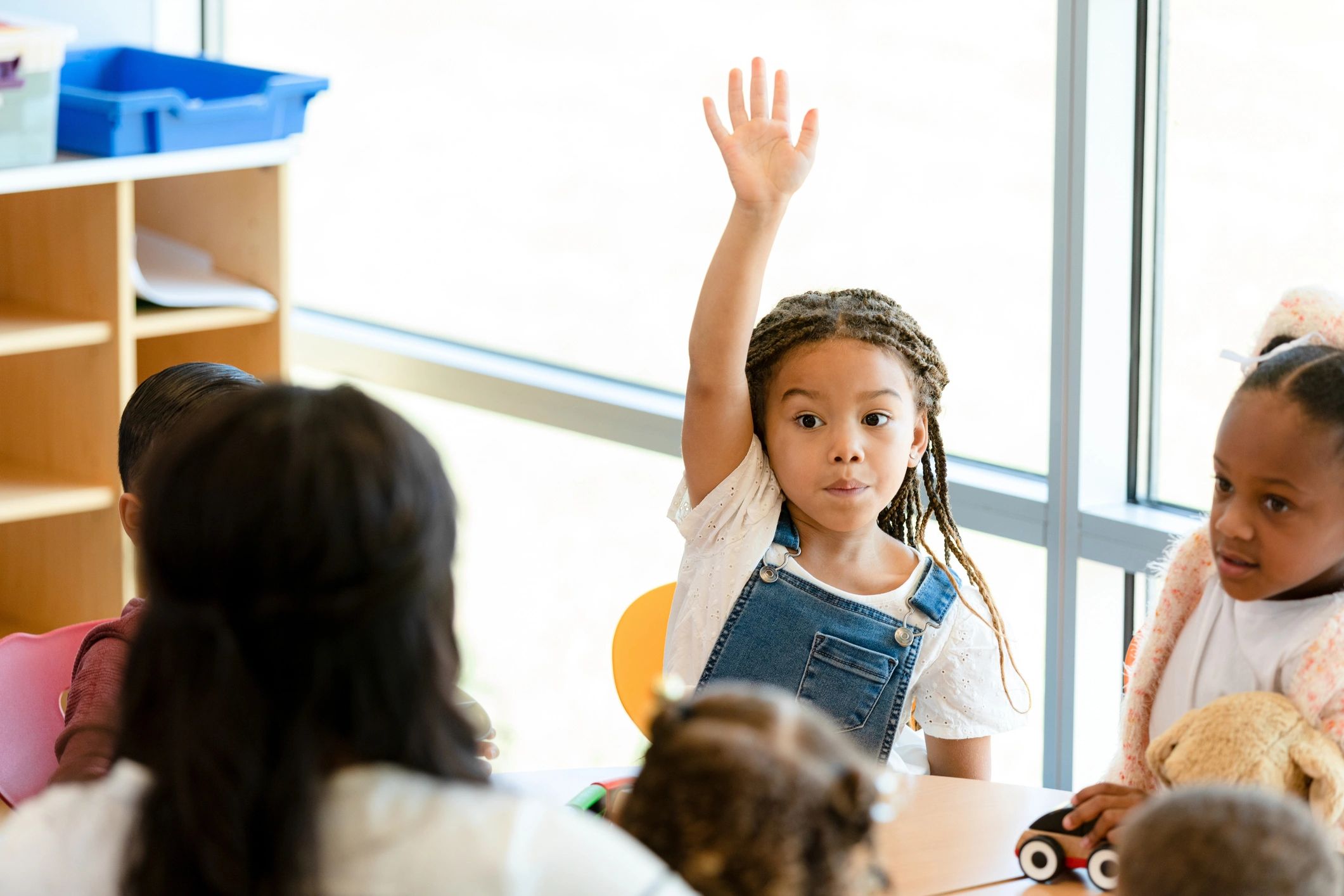 Child raising hand during preschool class
