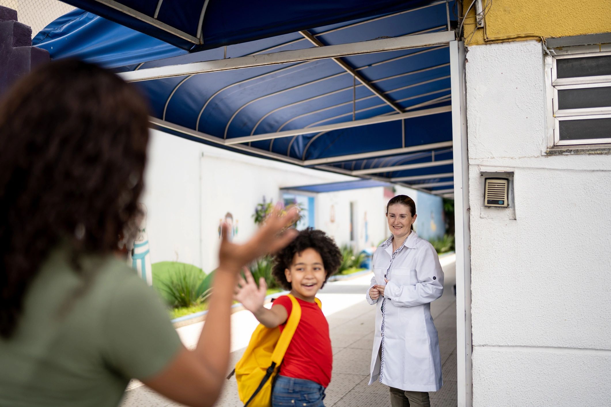 Parent greeting child at school entrance