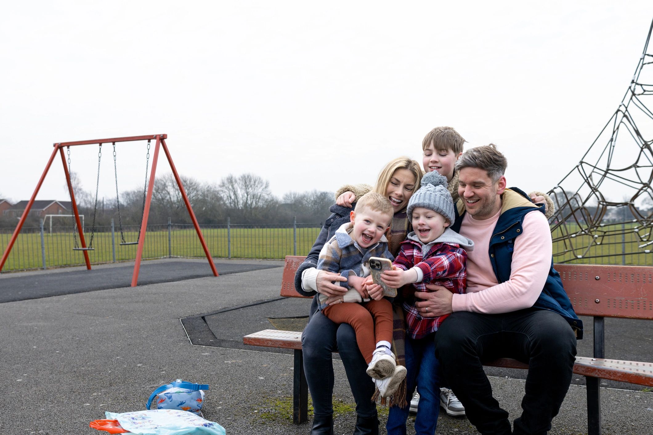 Smiling family sitting together at a park