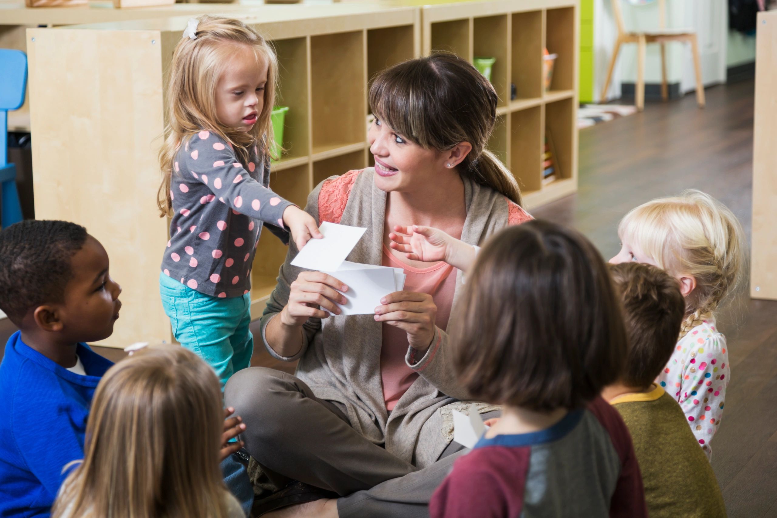 Teacher leading a group circle activity with children