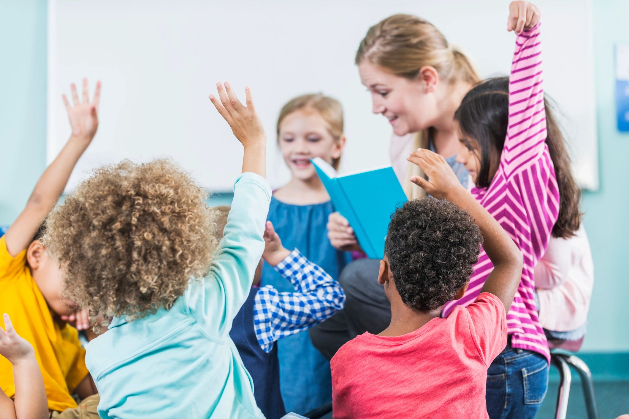 Teacher reading to kindergarten children in a circle